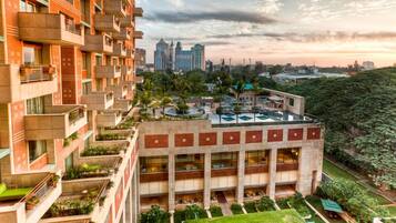 A multi-story building with a rooftop garden and a pool.