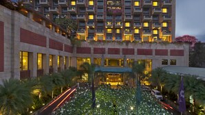 A multi-story hotel with a prominent entrance, balconies, and a well-lit facade.