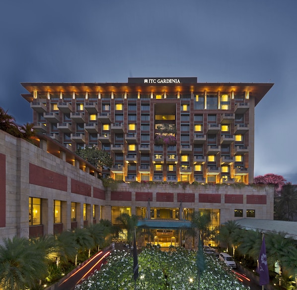 A multi-story hotel with a prominent entrance, balconies, and a well-lit facade. - ITC Gardenia, a Luxury Collection Hotel, Bengaluru (Bengaluru)
