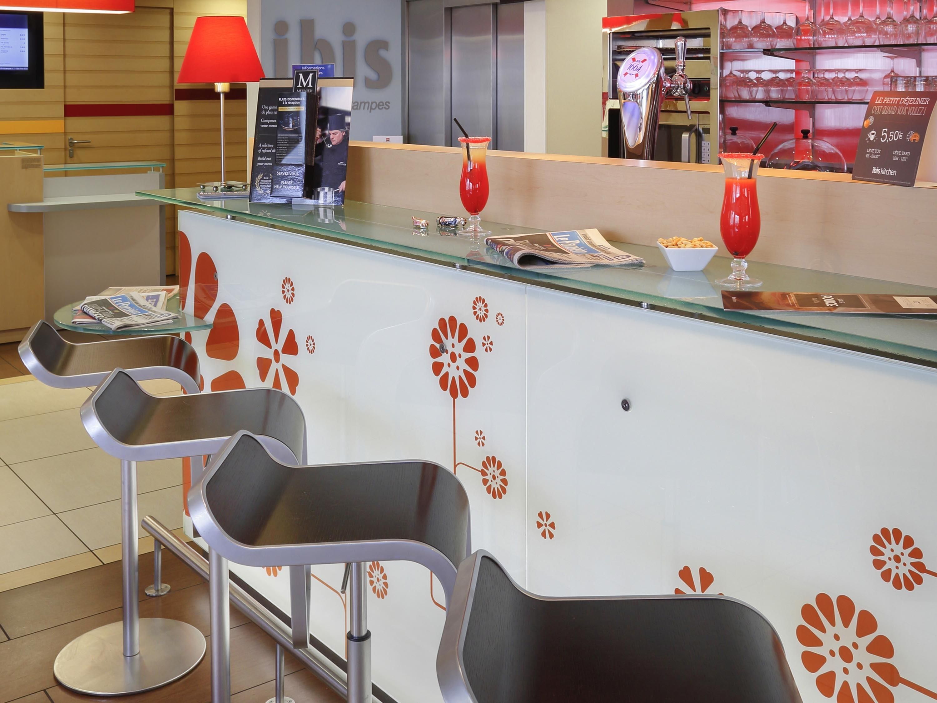 A reception area with a glass counter, modern chairs, and a red lamp.