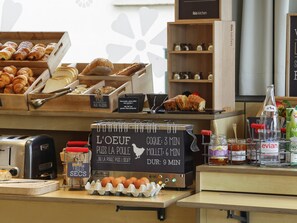 A bakery counter with various baked goods, a sign indicating preparation times for dishes, and a display of eggs and jars of preserves. - ibis Etampes (Etampes)