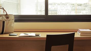 Un bureau avec un sac à main, un livre, un stylo et un téléphone intelligent.