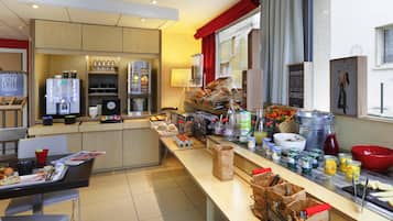 Cocina moderna con cafetera, refrigerador y diversos alimentos sobre la encimera.