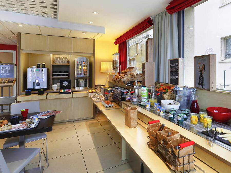 Cocina moderna con cafetera, refrigerador y diversos alimentos sobre la encimera.