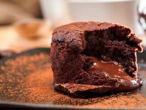 Un pastel volcán de chocolate con centro líquido, espolvoreado con cacao.