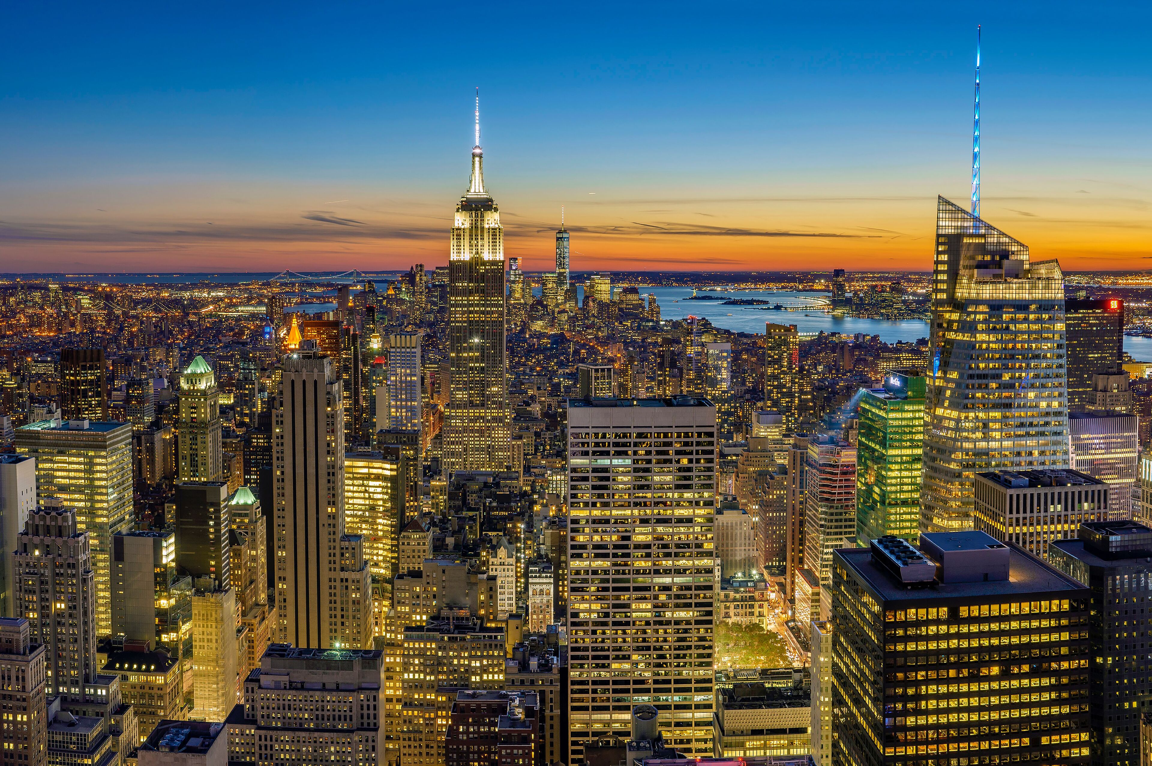 A cityscape with a prominent skyscraper featuring a spire, surrounded by other high-rise buildings.