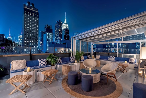 Relax on the rooftop terrace with comfortable seating and stunning city views.