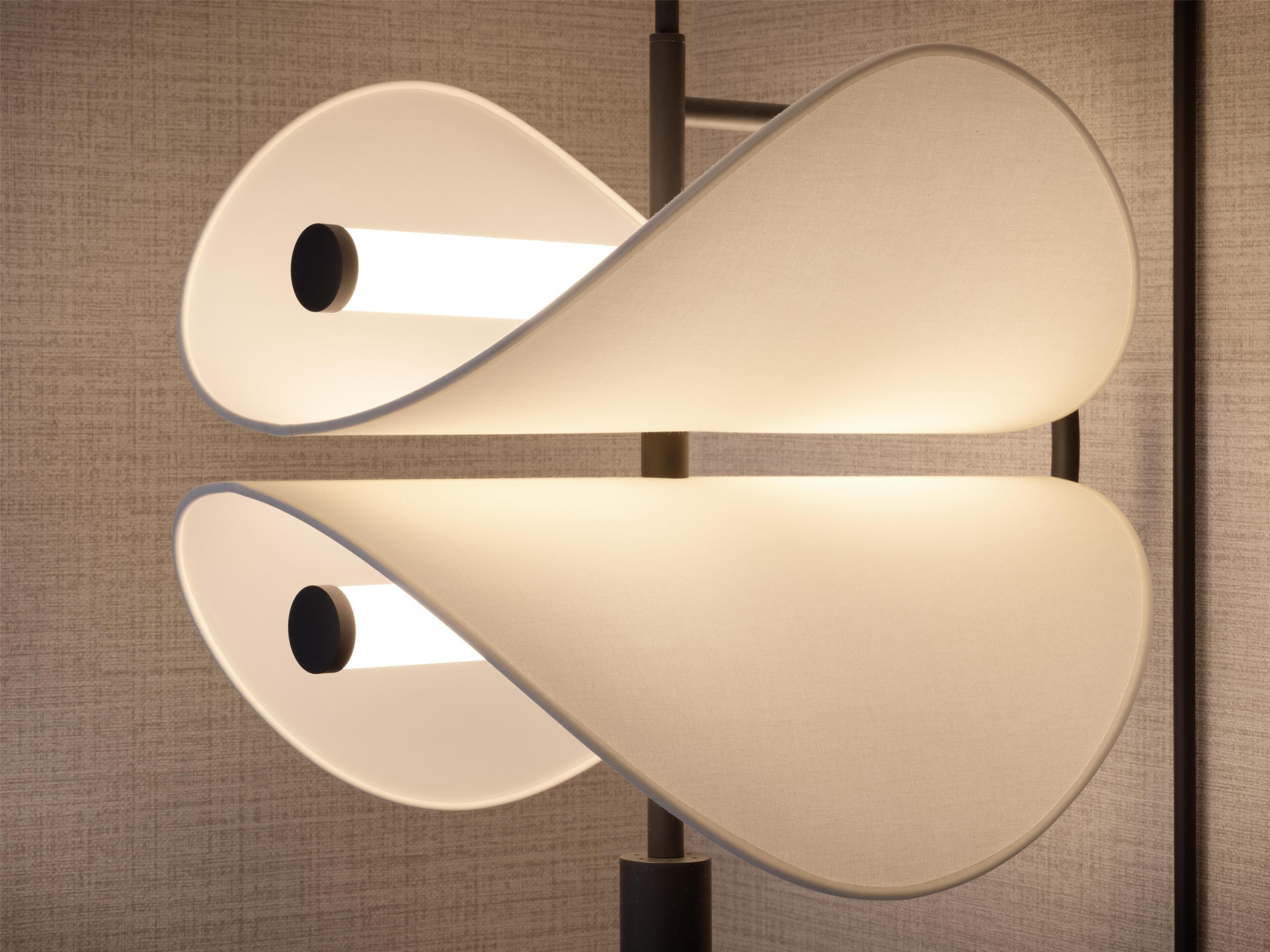 Een moderne lamp met een uniek ontwerp, bestaande uit twee kegelvormige lampenkappen en een centrale lichtbron.
