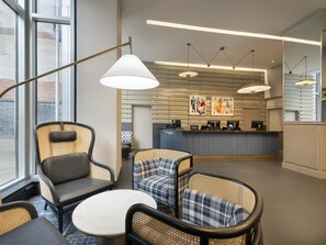 Relax in style at our lobby, featuring a reception desk, comfortable seating area, and modern artwork.