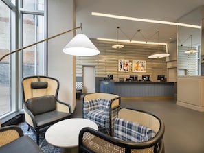 Relax in style at our lobby, featuring a reception desk, comfortable seating area, and modern artwork.