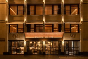 Fachada de hotel con entrada central, varios balcones y un letrero que dice "HOTEL DAME DES ARTS".