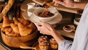 A breakfast buffet with various pastries, fruits, and a person serving themselves. - Hotel Dame des Arts (Paris)