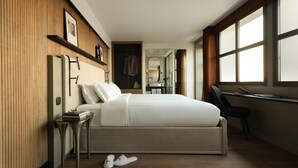 A modern bedroom with a large bed, a desk, and a walk-in closet. - Hotel Dame des Arts (Paris)