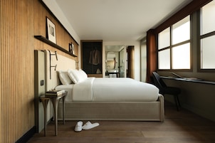 Un dormitorio moderno con una cama grande, un escritorio y un vestidor.