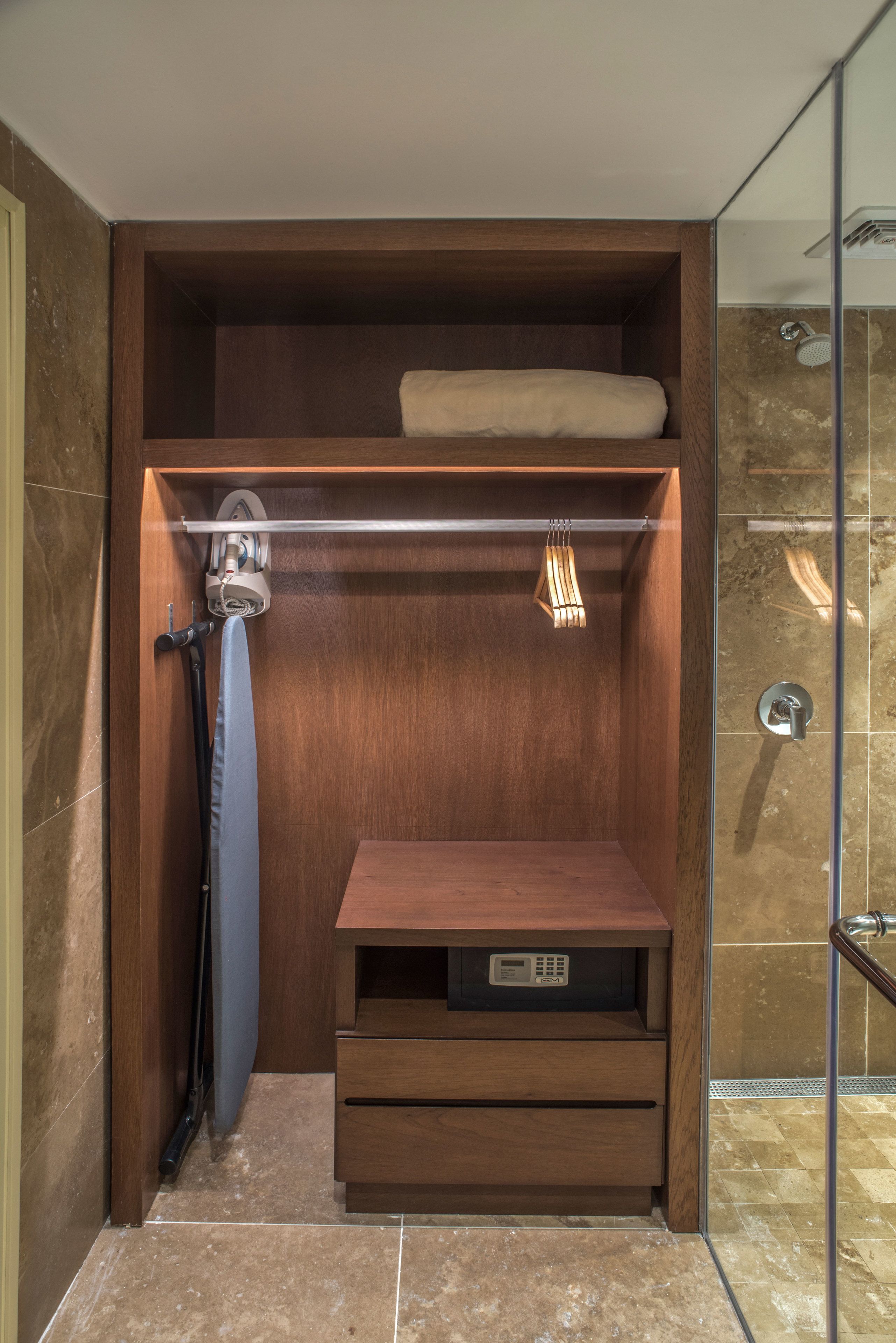 Un baño pequeño con un tocador de madera, un perchero para toallas y una zona de ducha.