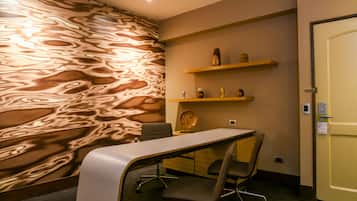 Work in style with a sleek desk and comfortable chair, surrounded by a unique textured wall and decorative shelves.