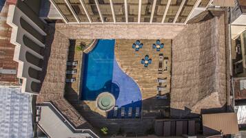 Relax by the pool surrounded by a wooden deck and lounge chairs.