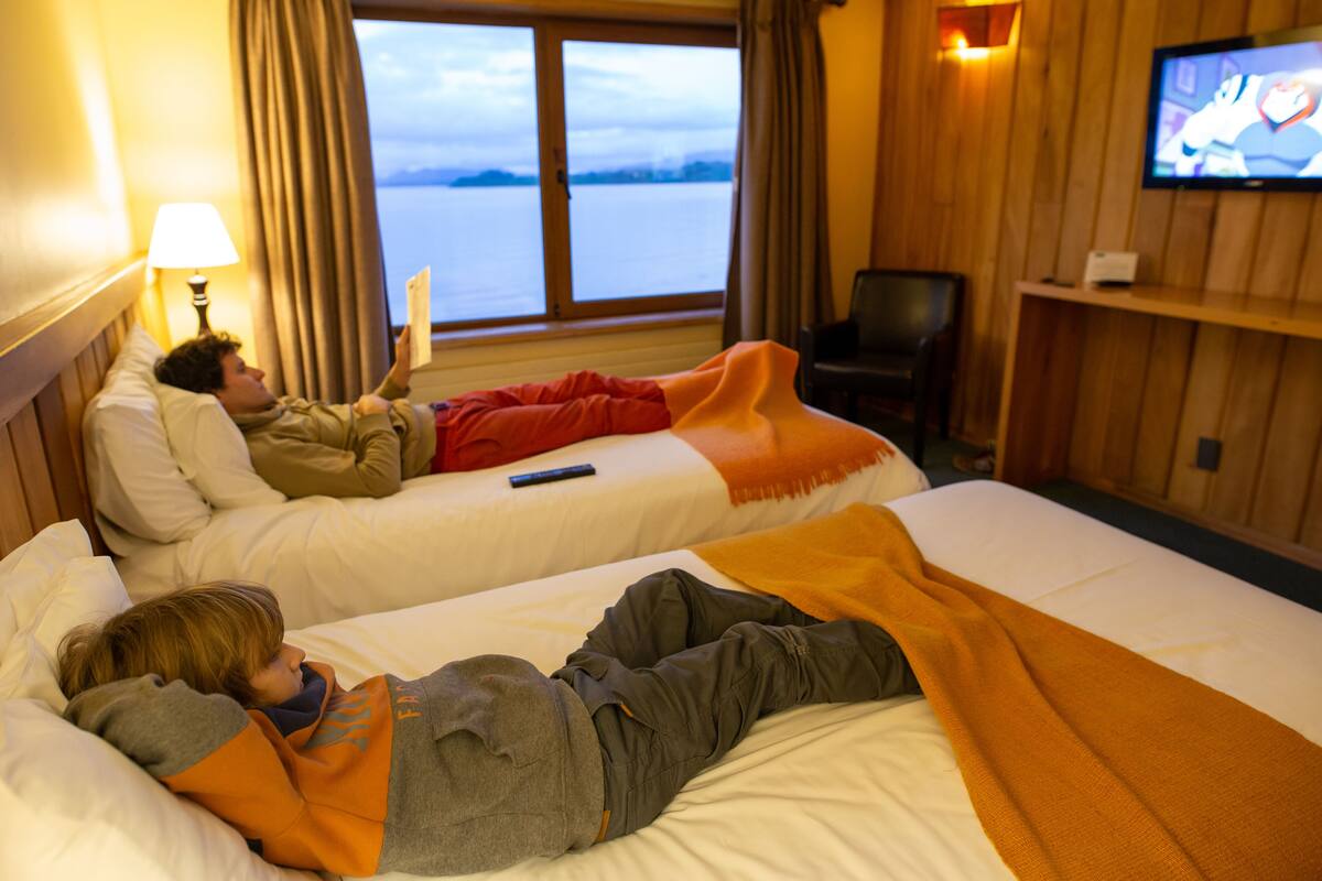 Une chambre d’hôtel avec deux lits, une télévision et vue sur l’eau.