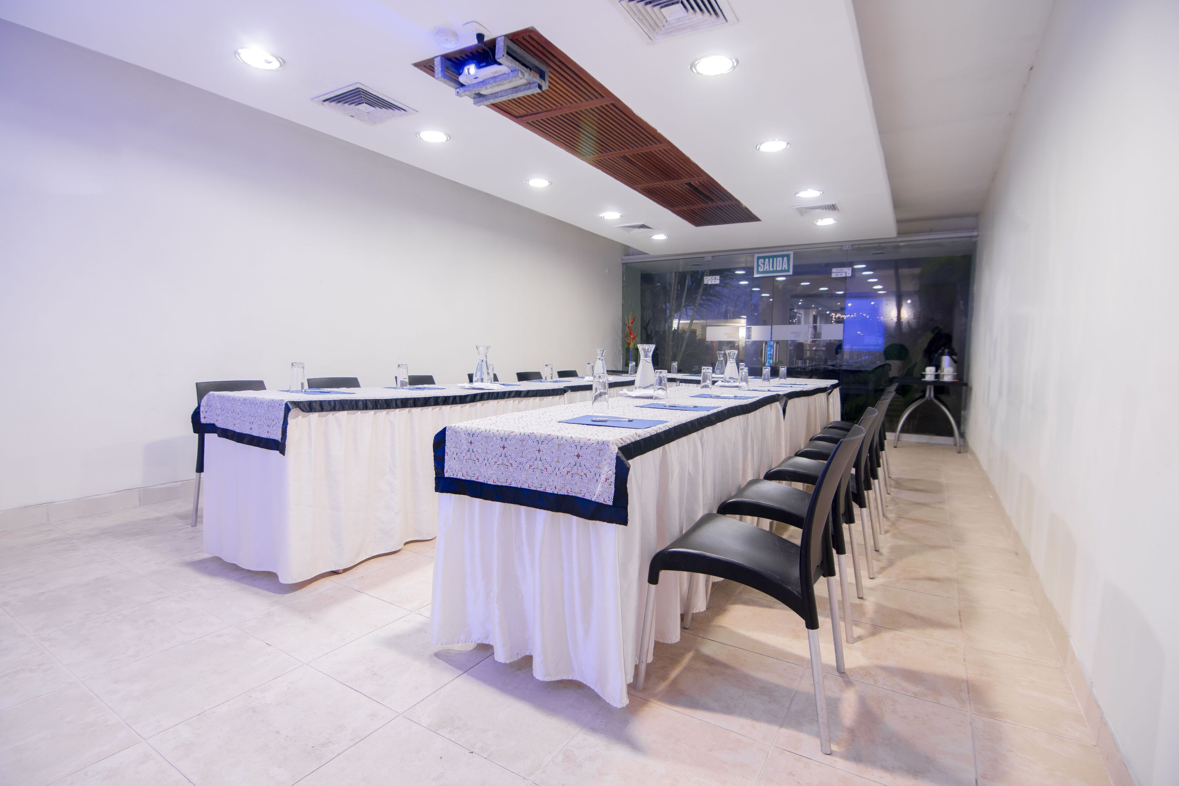 A conference room with a long table, chairs, and a glass wall.