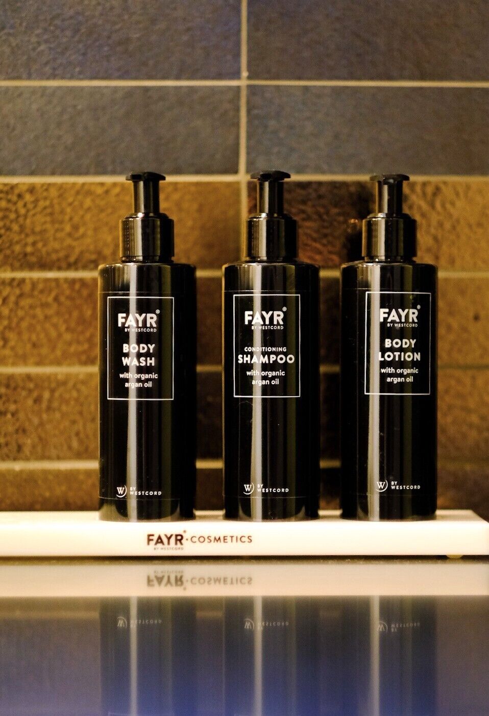 Three FAYR cosmetics bottles on a shelf.
