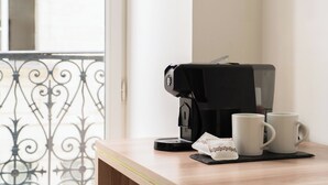 Una cafetera sobre una mesa con dos tazas blancas y una servilleta.