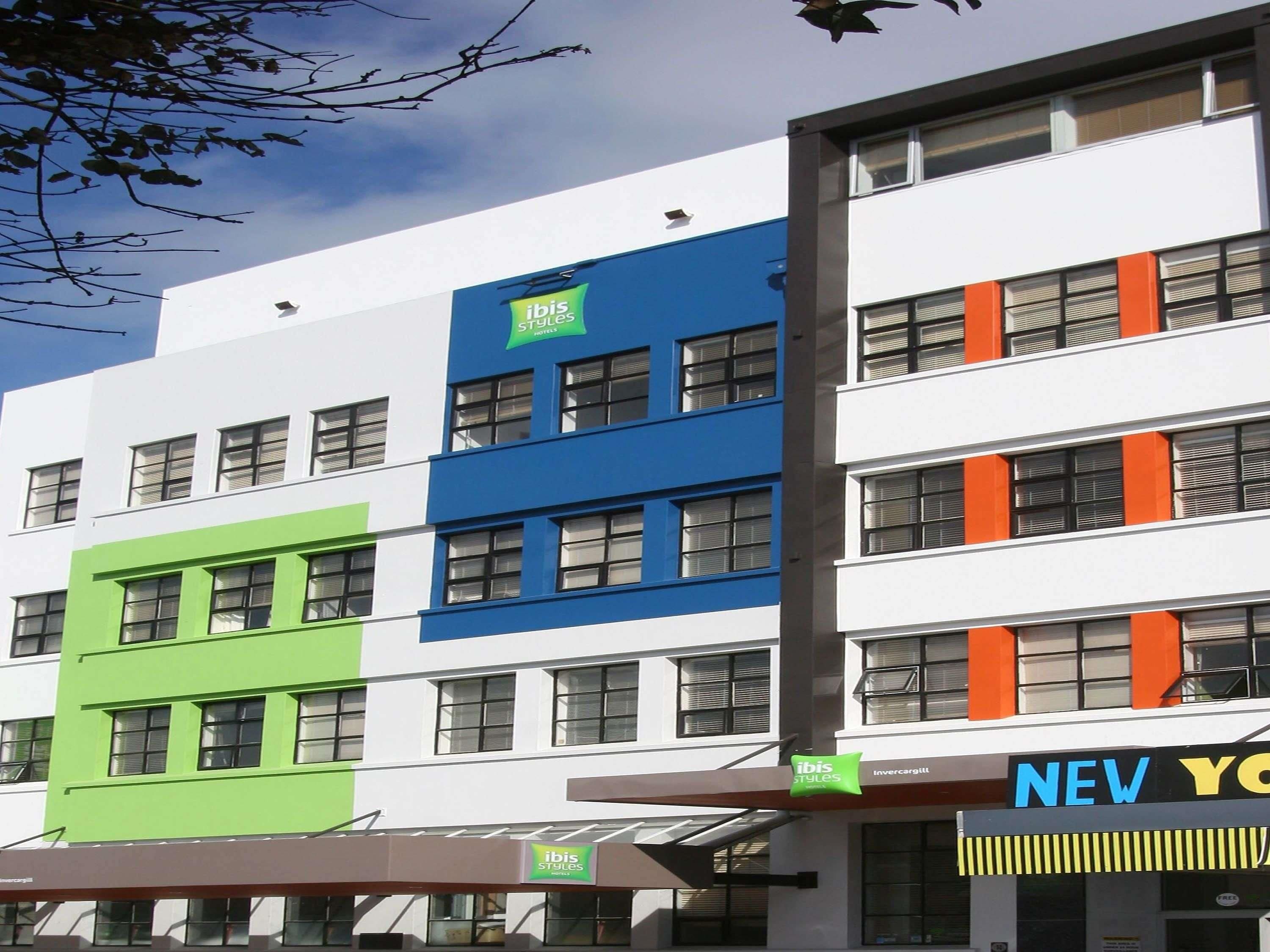 Un hotel de varios pisos con fachada moderna, destacando un letrero grande de 'ibis Styles'.