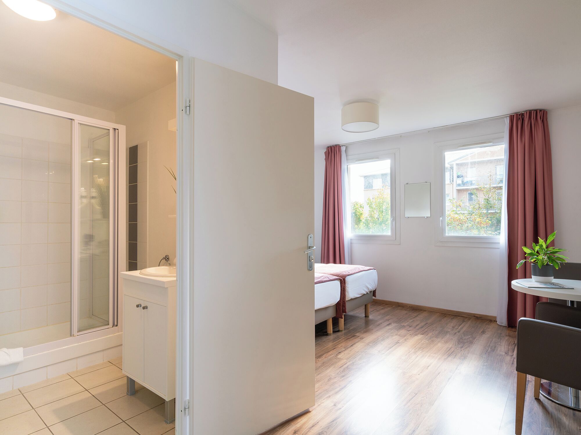 Een moderne badkamer met een douchecabine van glas, een witte wastafel en een toilet.