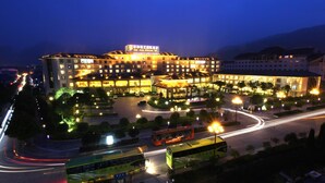 A large hotel with multiple buildings, a central courtyard, and a well-lit street with vehicles. - Qinghe Jin Jiang International Hotel (Zhangjiajie)