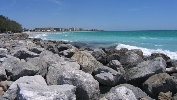 A rocky beach with large boulders in the foreground and a clear blue sky. - Fairfield Inn & Suites by Marriott Venice (Venice)