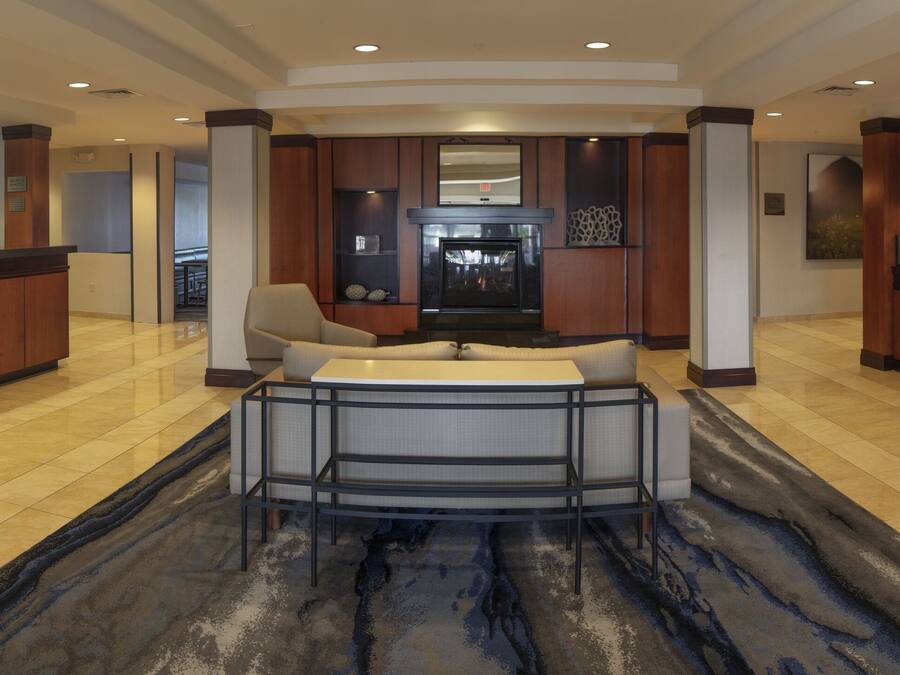 A spacious lobby with a central seating area, a reception desk, and a fireplace.