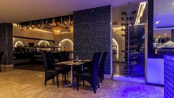 A restaurant with a bar area, seating, and a wine rack.