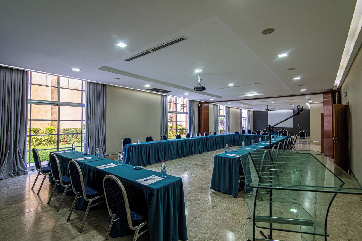 A conference room with long tables, chairs, and a projector.