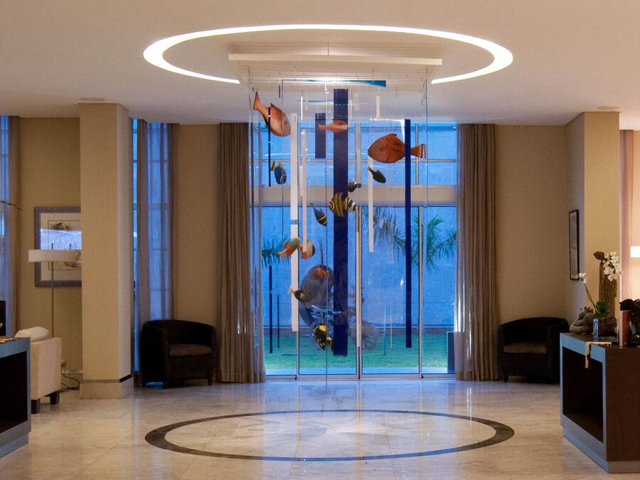 A lobby with a circular floor design, a fish aquarium, and two sofas.