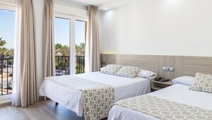 A hotel room with two beds, a balcony with curtains, and a view of palm trees. - Hotel Olympia Ronda II (Puig)