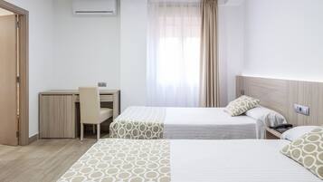 Una habitación de hotel con dos camas, un escritorio y una silla.