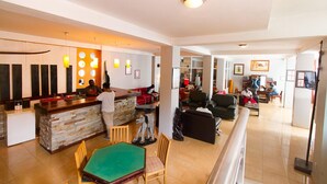 Un espacio habitable amplio con una mesa de comedor, una zona de bar y un área de estar con sofás.