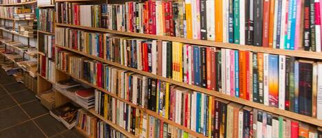 A library with multiple wooden bookshelves filled with books.
