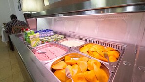 Un bufé con diversos alimentos, entre ellos frutas, lácteos y carnes.