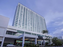 Un hotel moderno de gran altura con fachada contemporánea, amplias ventanas y una entrada destacada.