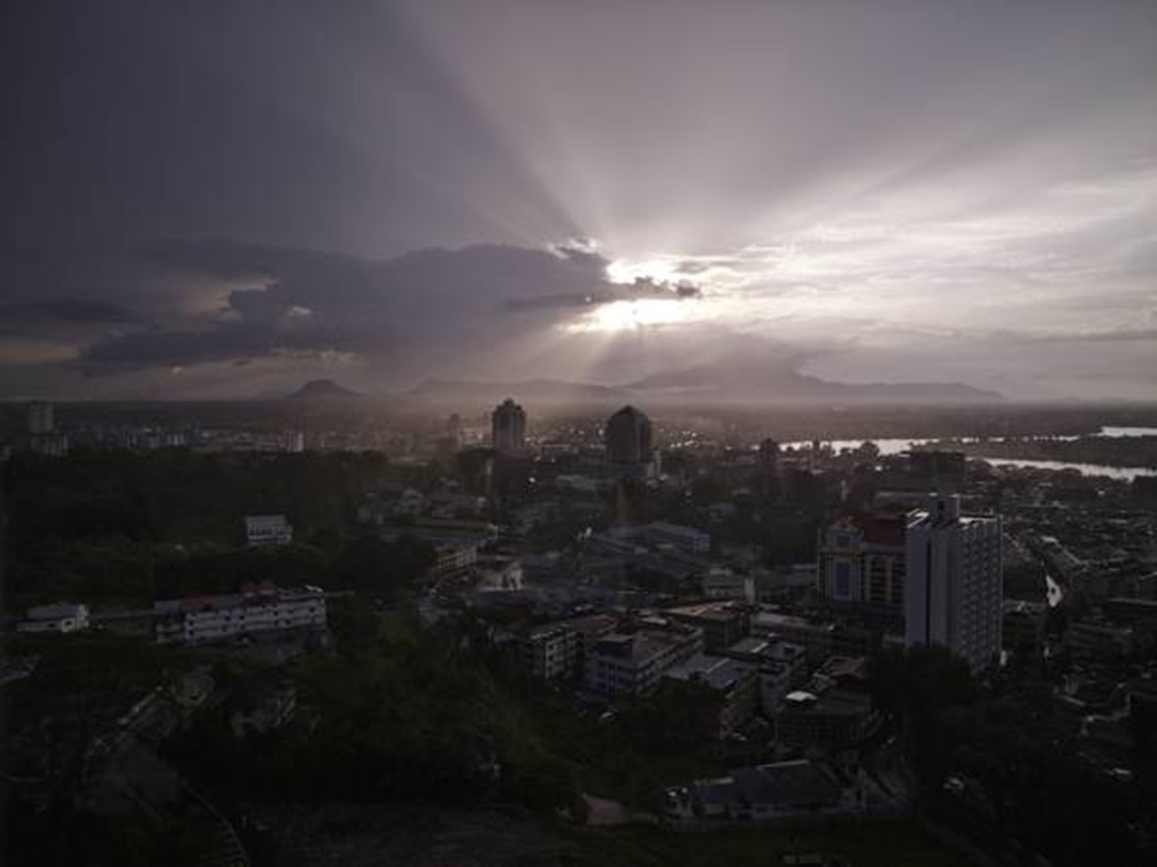A cityscape with buildings and a mountain in the background.