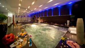 A spa area with a hot tub, seating, and a bar with drinks and fruits. - Pullman Kuching (Kuching)