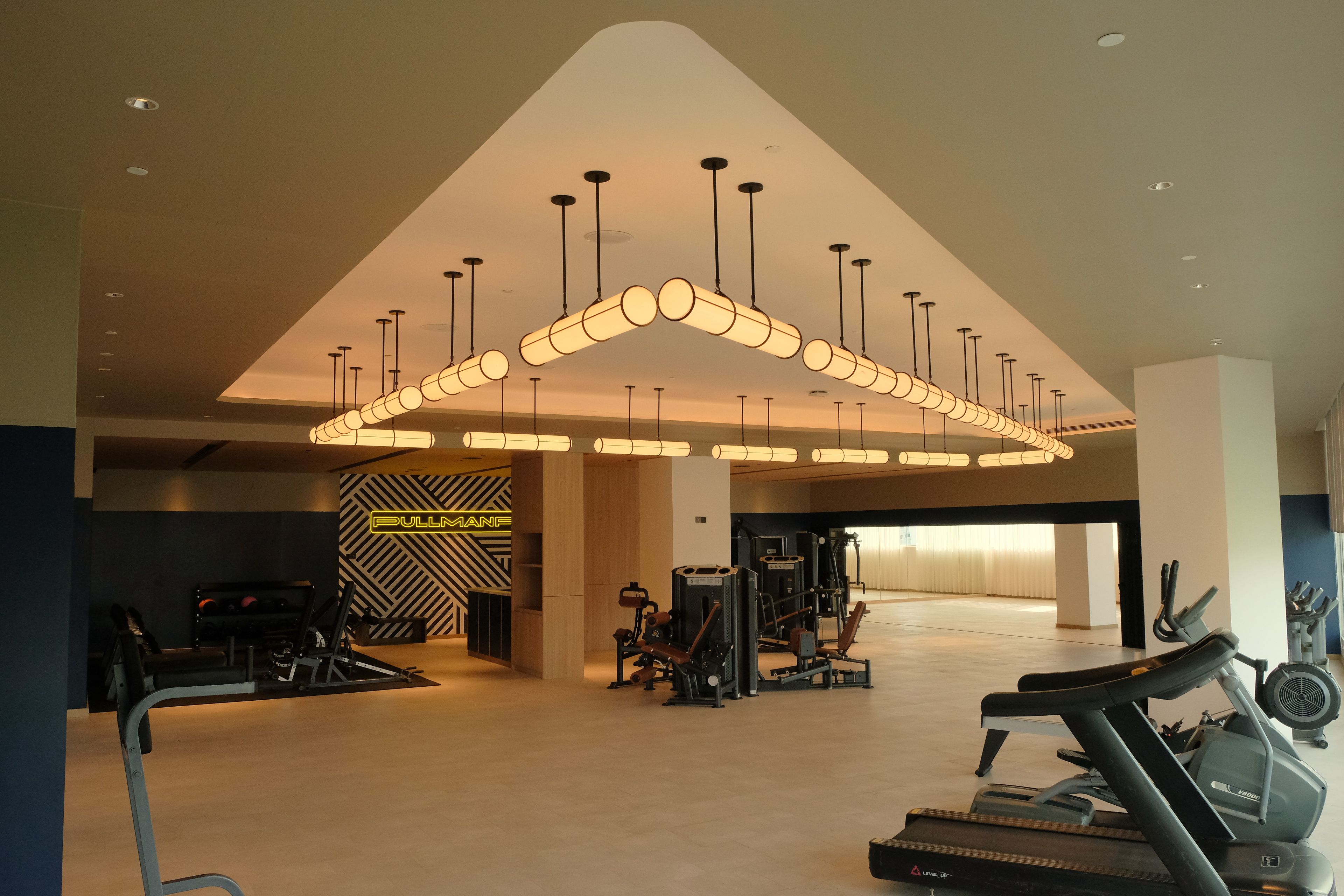 A modern gym with various exercise equipment, including treadmills and weight machines.