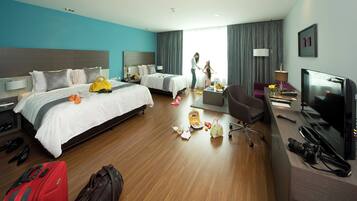 Habitación de hotel con dos camas, un escritorio con televisor, una silla y espacio para equipaje.