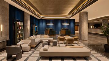 A modern lobby with a checkered floor, a sectional sofa, and a reception desk.