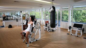 Un gimnasio con máquinas de cardio, equipo de levantamiento de pesas y un saco de boxeo.