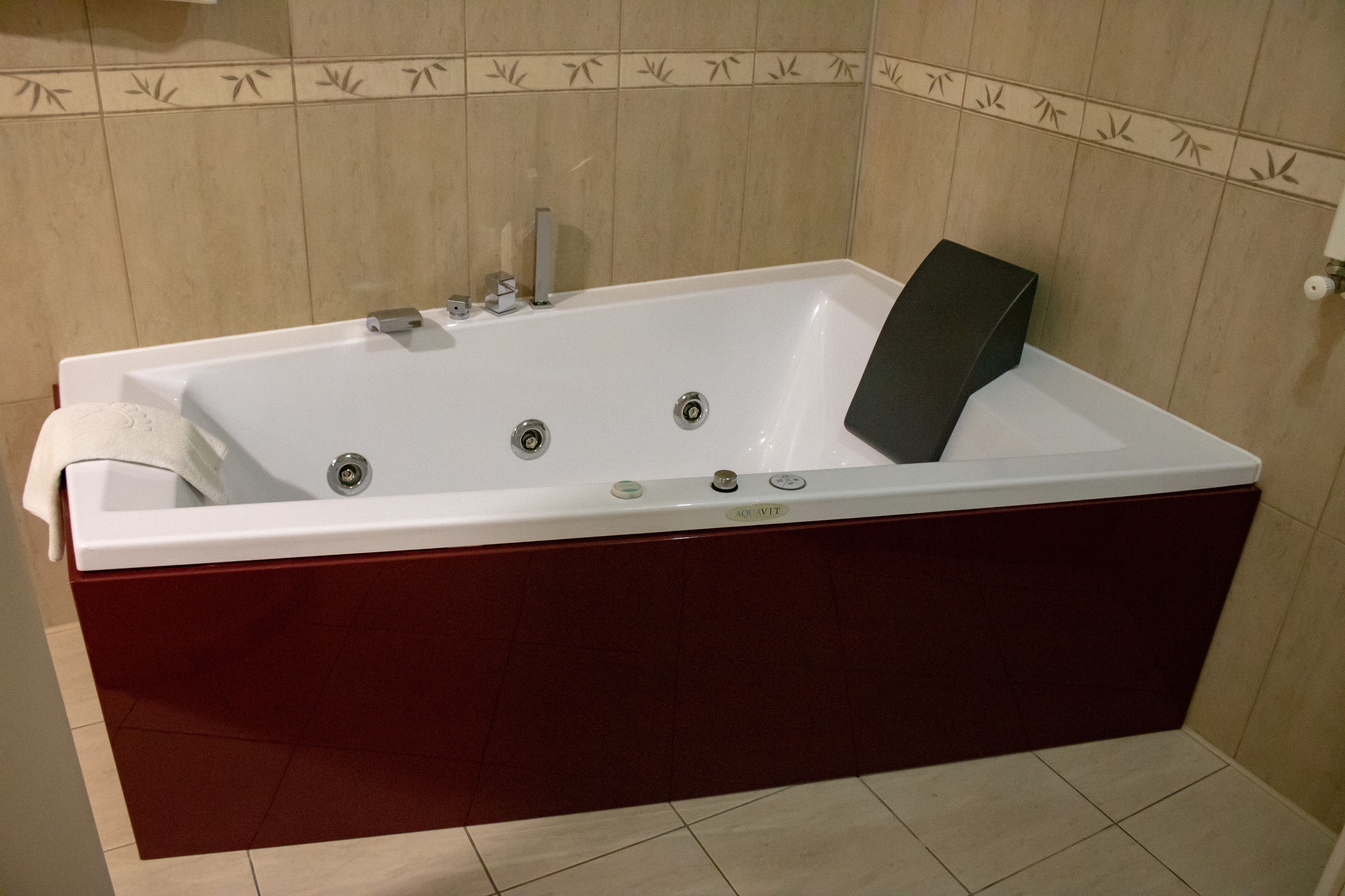 Eine rechteckige Badewanne mit Holzfuß und weißem Wanneneinsatz.