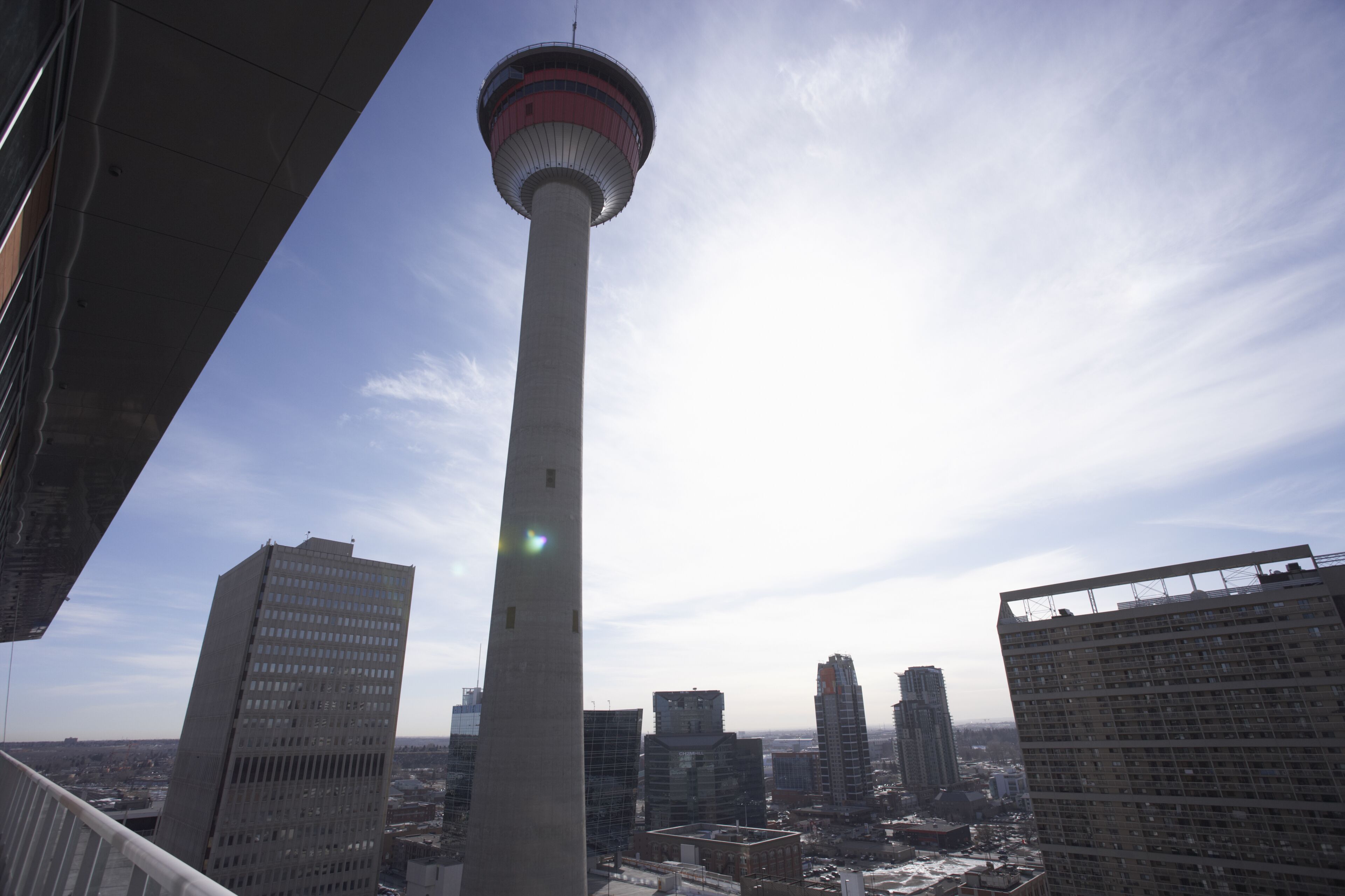 A tall tower with a circular observation deck, surrounded by modern high-rise buildings.
