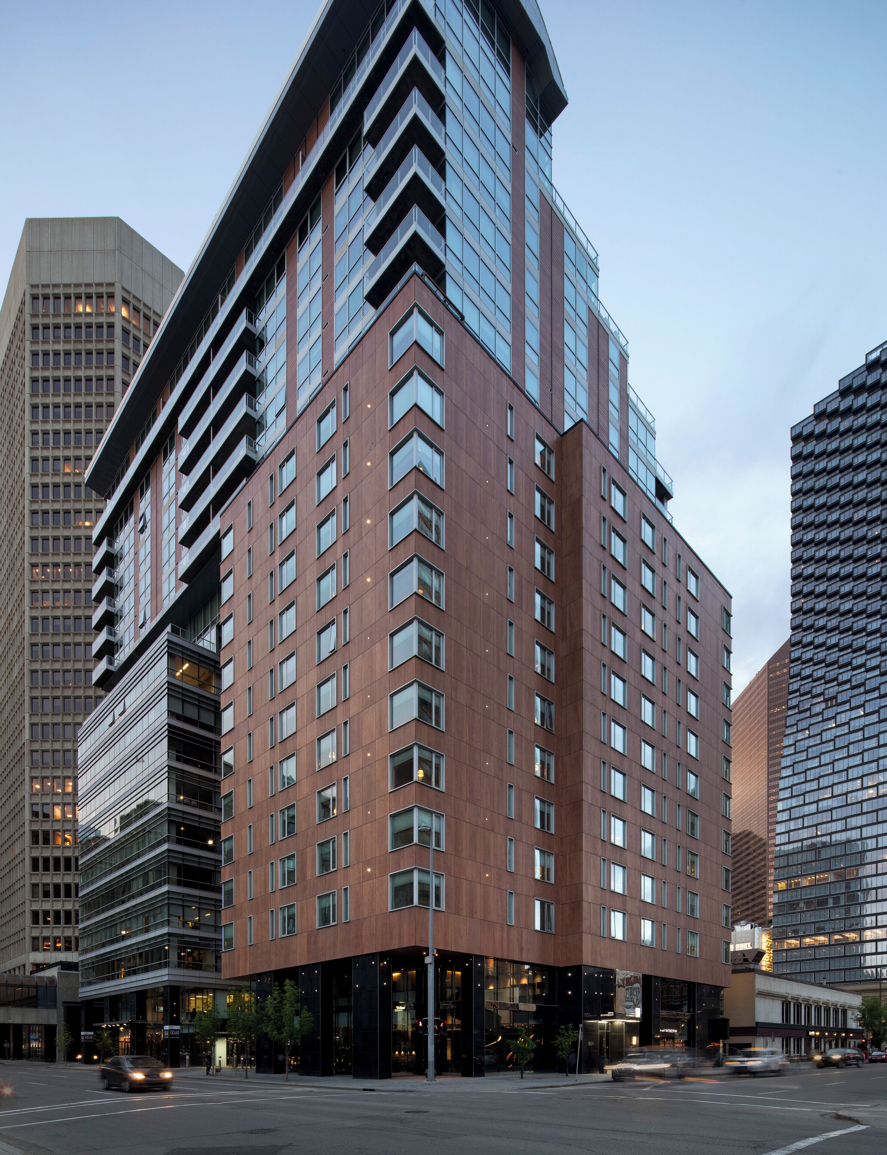 A modern high-rise building with multiple floors, large windows, and a prominent corner design.
