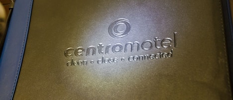A brown leather folder with embossed text reading "Centromotel clean close connected."