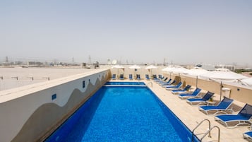 Een buitenzwembad, parasols voor strand/zwembad